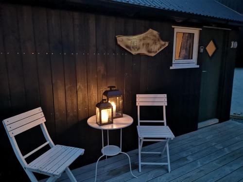 SandavágurHjallurin的甲板上配有两把椅子和一张带蜡烛的桌子