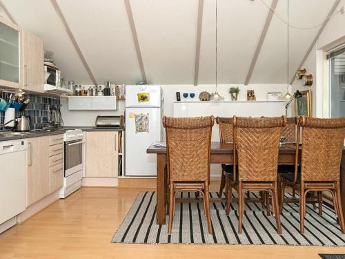 福旺6 person holiday home in F rvang的厨房配有桌椅和冰箱。