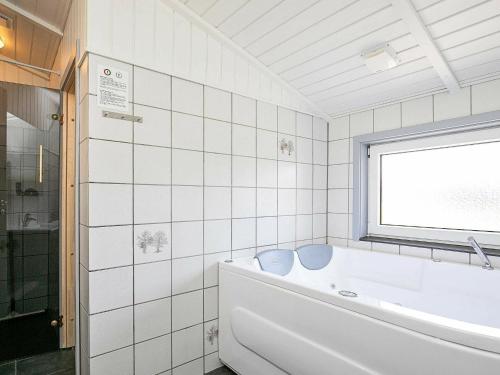 瓦伊厄斯斯特兰德8 person holiday home in Vejers Strand的白色的浴室设有浴缸和窗户。