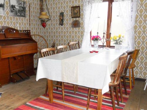 Agunnaryd6 person holiday home in RYSSBY的一间设有白色桌子和钢琴的用餐室
