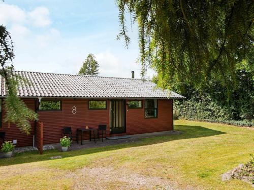 锡尔克堡5 person holiday home in Silkeborg的一间红色的小房子,前面有一张桌子