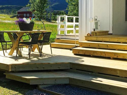 Mefjordvær6 person holiday home in Senjahopen的木制甲板配有桌子和桌椅