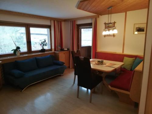 东蒂罗尔地区马特赖Haus Rainer的客厅配有蓝色的沙发和桌子