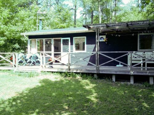 锡尔克堡4 person holiday home in Silkeborg的蓝色的小房子,树林里有一个门廊