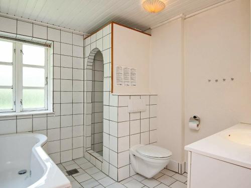 诺德堡Holiday Home Møllebækvej的白色的浴室设有卫生间和水槽。