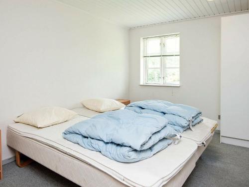 诺德堡Holiday Home Møllebækvej的白色客房,配有蓝色毯子