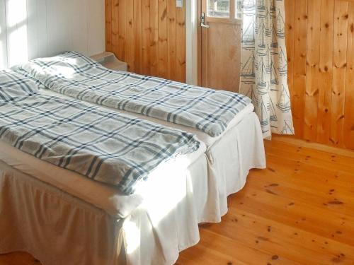 FreiHoliday Home Rensvikholmen的床上有蓝色和白色的毯子