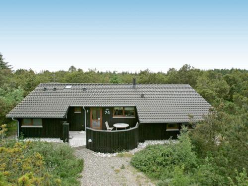 图鲁普斯特兰德8 person holiday home in Fjerritslev的前面有一张桌子的黑色房子