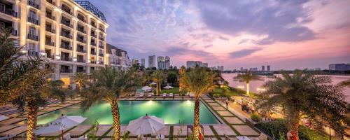 胡志明市Mia Saigon – Luxury Boutique Hotel的享有酒店游泳池和棕榈树的景色