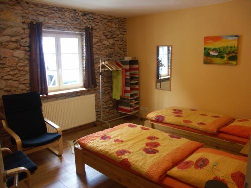温特贝格伊斯多鲁斯住宿加早餐旅馆的一间卧室设有两张床、一把椅子和一个窗户。