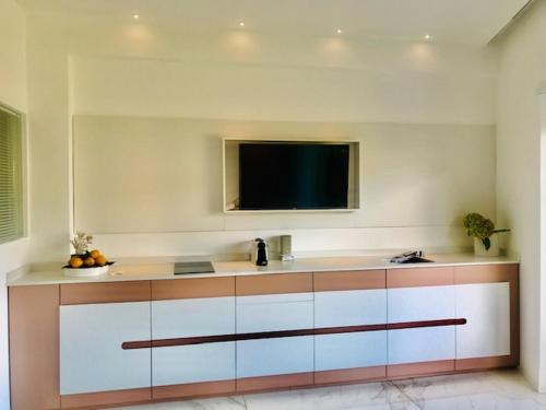 特罗佩阿S'O Suites Tropea的厨房配有壁挂式平面电视。