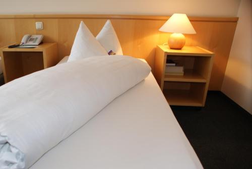 帕尔斯多夫赫里安酒店的酒店客房设有一张带灯的白色大床