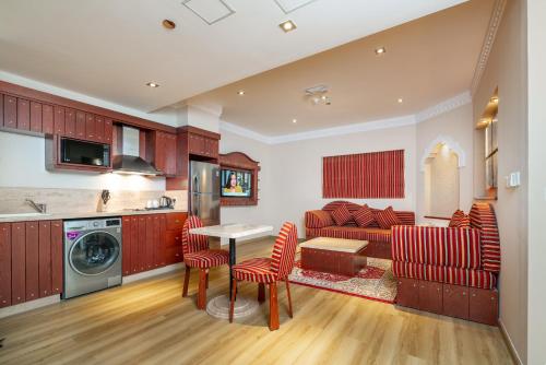 多哈Al Liwan Suites Rawdat Al Khail的厨房以及带桌椅的起居室。