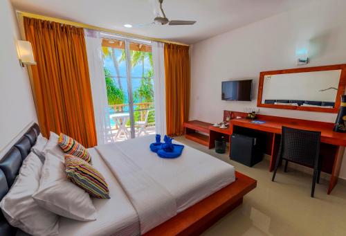 迪古拉阿提里马尔代夫海滩酒店的一间卧室配有一张床、一张书桌和一台电视