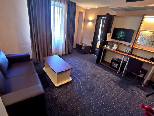 索非亚Elate Plaza Hotel的一间配备有沙发及电视的酒店客房