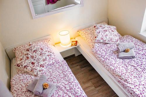 SuderburgWaldhaus Emma的配有2张床位的小卧室配有台灯和枕头