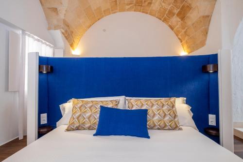 休达德亚Divina Suites Hotel Singular -Adults Only的一张带蓝色床头板的床和两个枕头