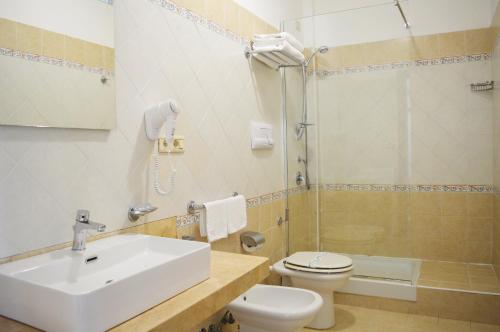 帕埃斯图姆Paestum Inn Beach Resort的一间带水槽、卫生间和淋浴的浴室