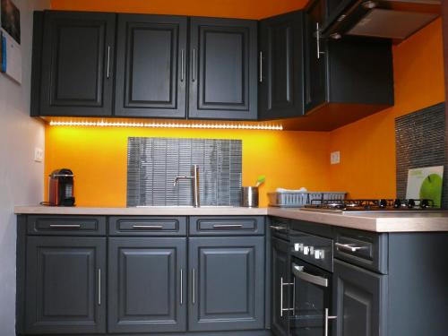 Leernes拉马拉维斯乡间渡假屋酒店的厨房配有黑色橱柜和橙色墙壁