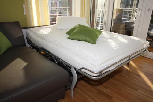 库克斯港Wohnen am Yachthafen W45的一张病床,上面有绿色枕头