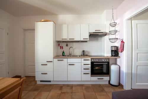 格拉尔-米里茨Ferienwohnung HIMBEERE mit großem Garten的小厨房配有白色橱柜和炉灶。