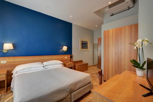 都灵阿斯特酒店的一间卧室设有一张床和蓝色的墙壁