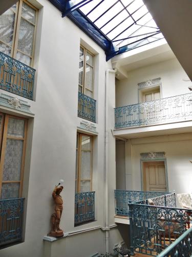 卡斯特尔萨拉桑HOTEL MARCEILLAC的拥有蓝色阳台和天窗的建筑