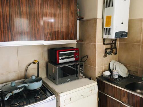 库里科Apart Hotel Curicó的小厨房配有炉灶和微波炉