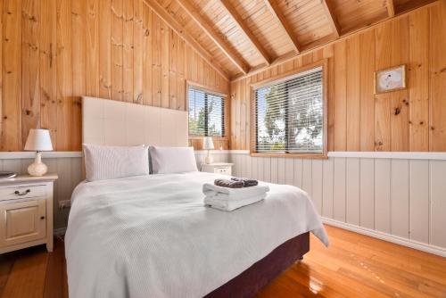 Exeter哈兹极客小屋酒店的一间带一张大床的卧室,位于带木墙的房间