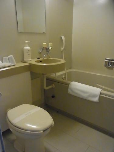 山形市新最上屋酒店的浴室配有卫生间、盥洗盆和浴缸。