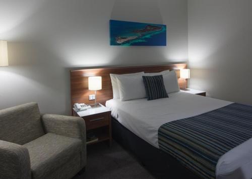 杰拉尔顿海洋中心酒店的配有一张床和一把椅子的酒店客房