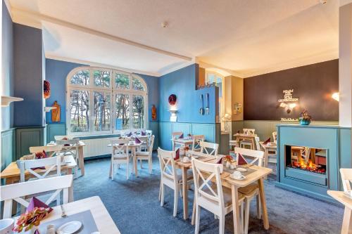 塞巴特阿尔贝克塞西洛彻别墅酒店的一间带桌椅和壁炉的餐厅