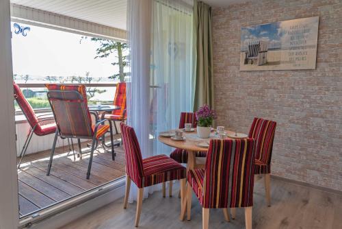 奥特里德维茨Haus Inselperle mit Blick auf den Bodden的一间带桌椅的用餐室和一个阳台