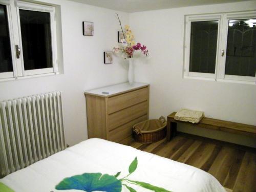 茹瓦尼Grand appartement dans villa avec parking quartier résidentiel的卧室配有一张床,梳妆台上摆放着花瓶