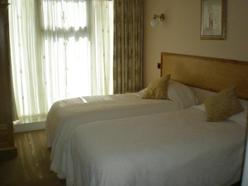 斯基普顿梅森斯阿尔姆斯旅馆的配有窗户的酒店客房内的两张床