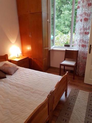 特里亚夫纳Къща Чалъкови的一间卧室设有一张床、一个窗口和一把椅子