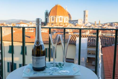 佛罗伦萨鲁比诺住宿加早餐旅馆的桌子上放有一瓶葡萄酒和两杯酒
