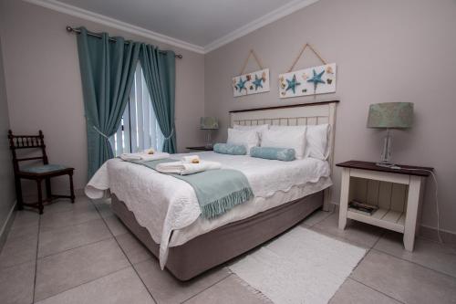 贝蒂湾Van Den Berg's Guesthouse的一间卧室配有一张床,上面有两条毛巾