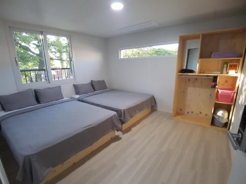 济州市Yong Stay的一间卧室设有两张床和两个窗户。