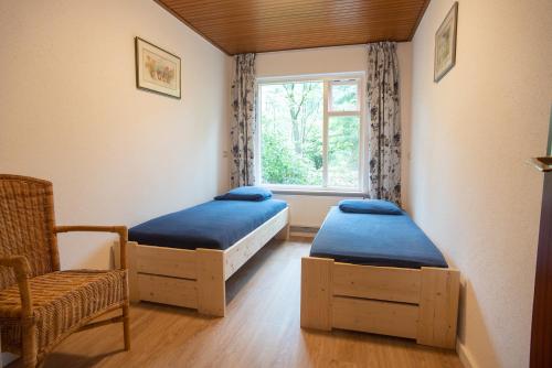 Lage MierdeBungalowpark Vogelenzang的配有2张床的带窗户和椅子的客房