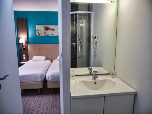 克里昂Contact Hotel Le Seino Marin - Cléon Elbeuf的一间带水槽的浴室和一间带一张床的卧室