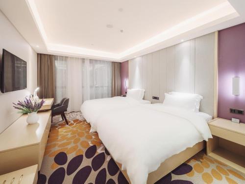 贵阳麗枫酒店·清镇职教城时光贵州店的酒店客房设有一张大床和一张书桌。