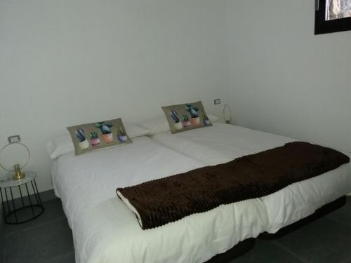丰卡连特德拉帕尔马Casa El Mirador的卧室配有一张带三个枕头的大型白色床
