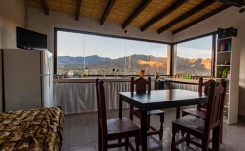 卡奇Cabaña Abra Del Monte的一个带桌椅和大窗户的厨房