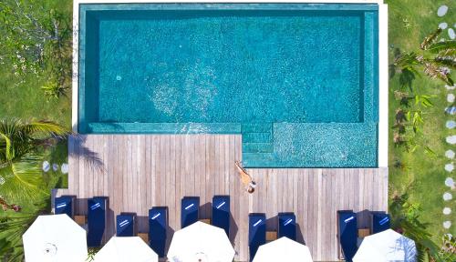 塞隆贝拉纳克Segara Lombok Beach Resort的享有带蓝色椅子的游泳池的顶部景致