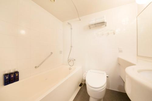 山形市山形站前里士满酒店的白色的浴室设有卫生间和浴缸。