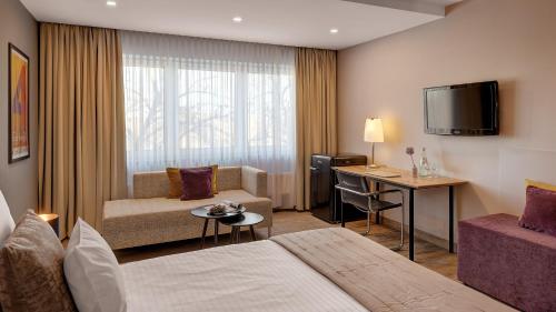 霍夫中心酒店的酒店客房配有一张床、一张沙发和一张书桌。