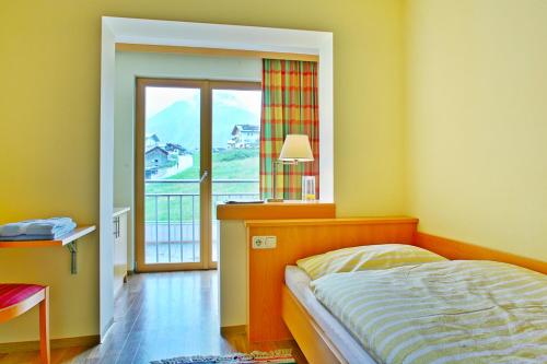 莱赫阿尔贝格Der Lecher的一间卧室设有一张床和一个美景窗户。