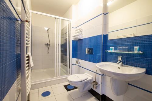 HoromysliceGreensgate Hotel Dýšina的蓝色和白色的浴室设有水槽和卫生间