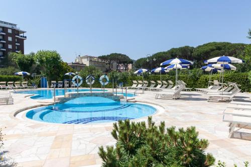 米兰马瑞提那卡立雅大酒店的度假村的游泳池配有椅子和遮阳伞